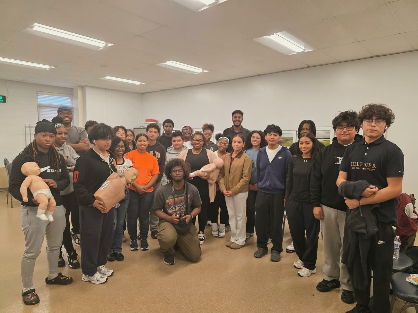 Young people celebrate completing a GoodWorks training with CPR manikins
